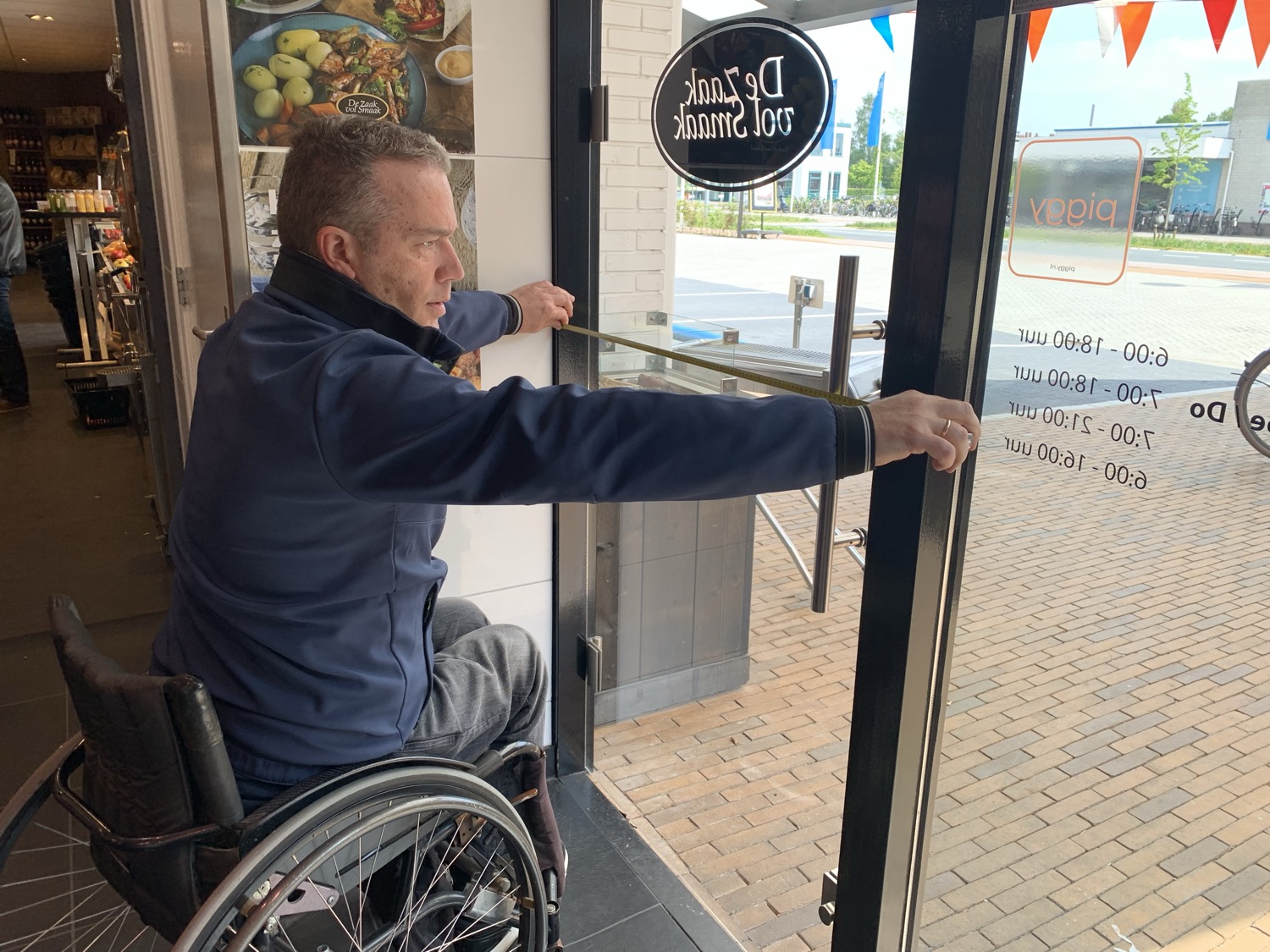 Peter meet de opening van een deur op.