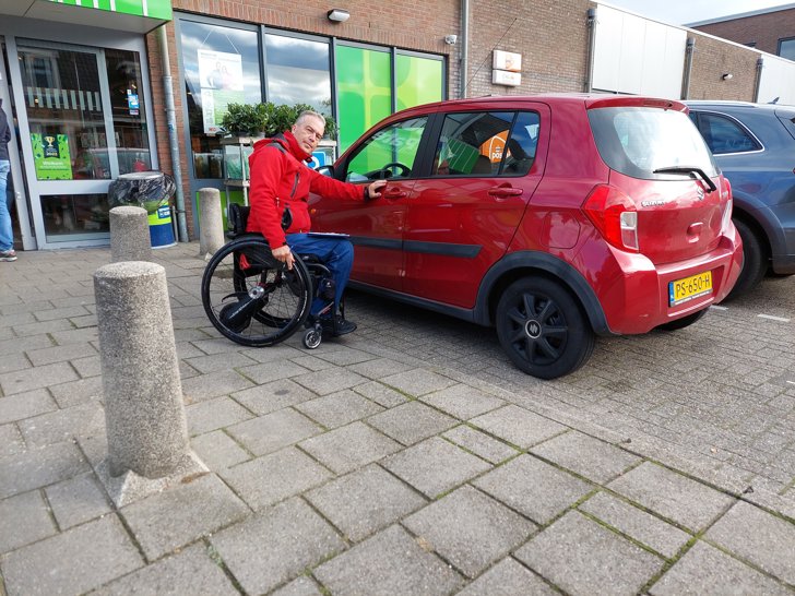 Ben Oorsprong kijkt naar de toegankelijkheidssituatie terwijl Peter de Bliek de drempel van de winkel opmeet.